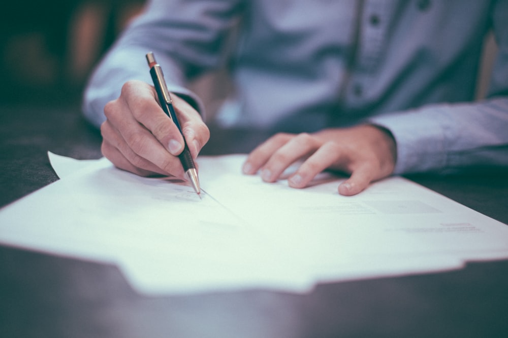 Two advocates reviewing and signing papers at a chambers desk